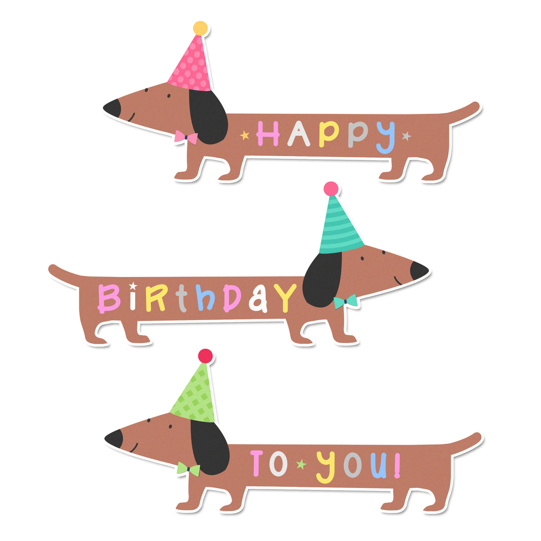 A close-up of a cupcake topper of a birthday dachshund featuring a party hat and bowtie.