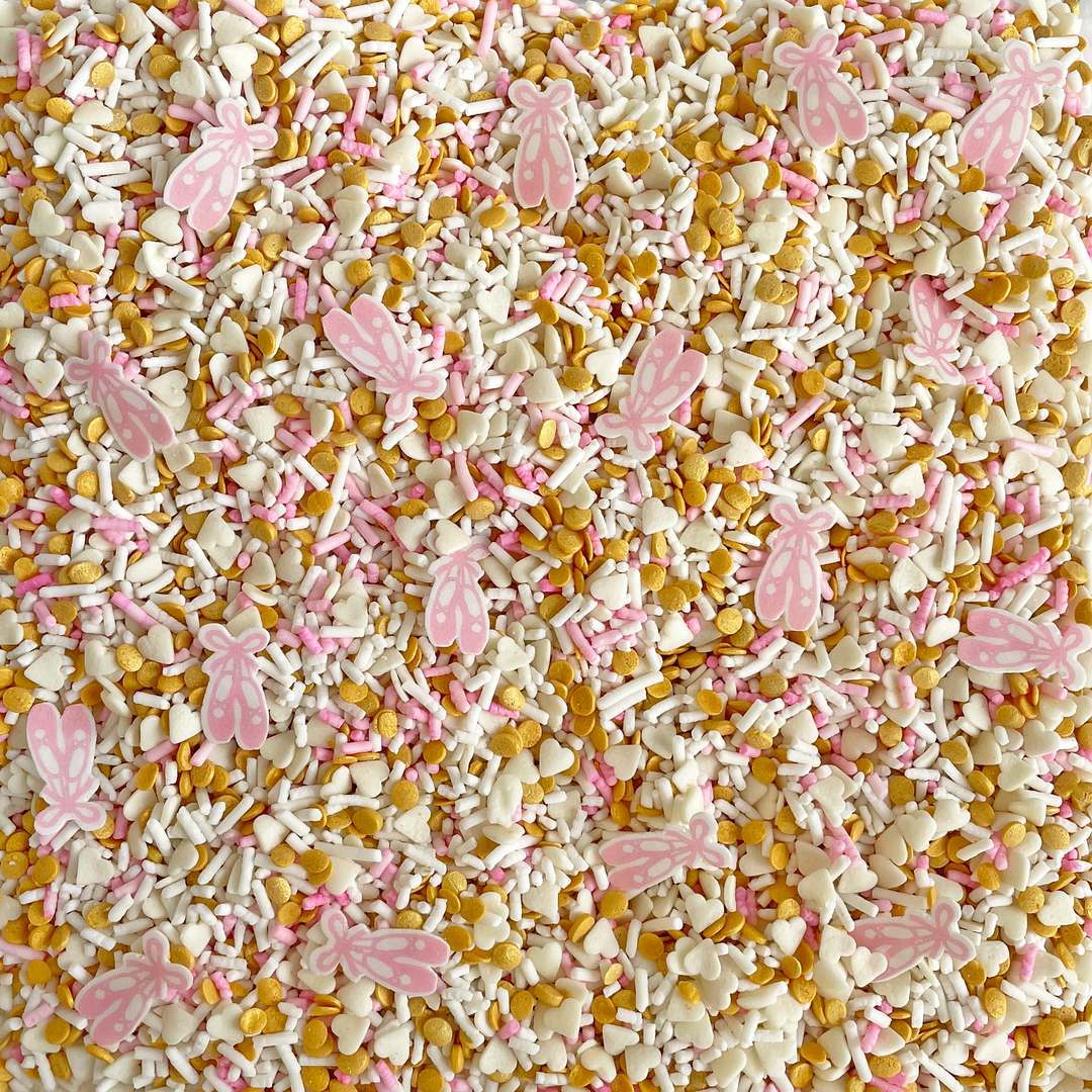 A close-up of Ballet Slipper Sprinkle Mix, featuring light pink and white sprinkles with wafer paper ballet slipper shapes.