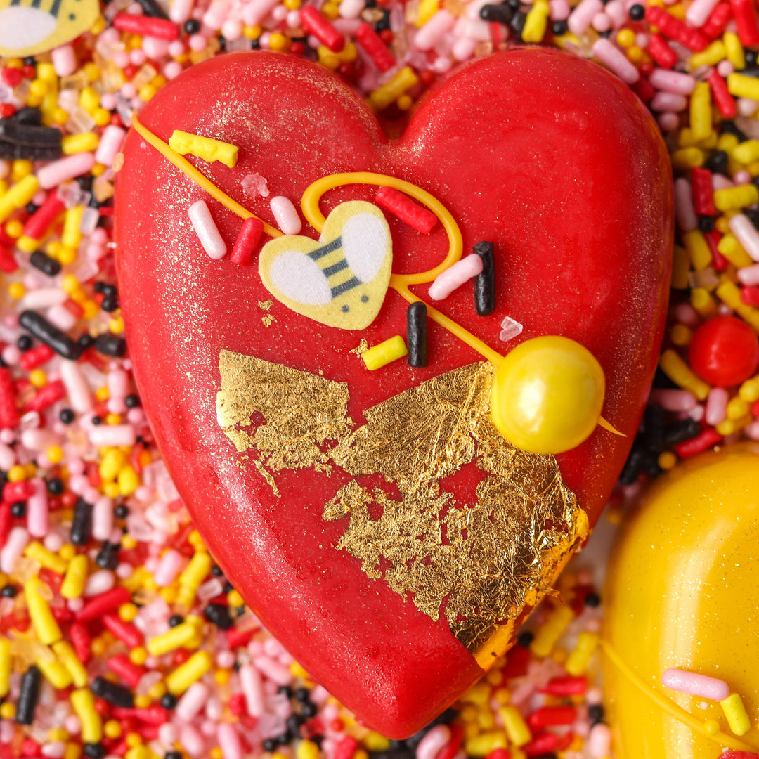 Red heart shaped cake pop topped with our bee mine valentines day sprinkle mix