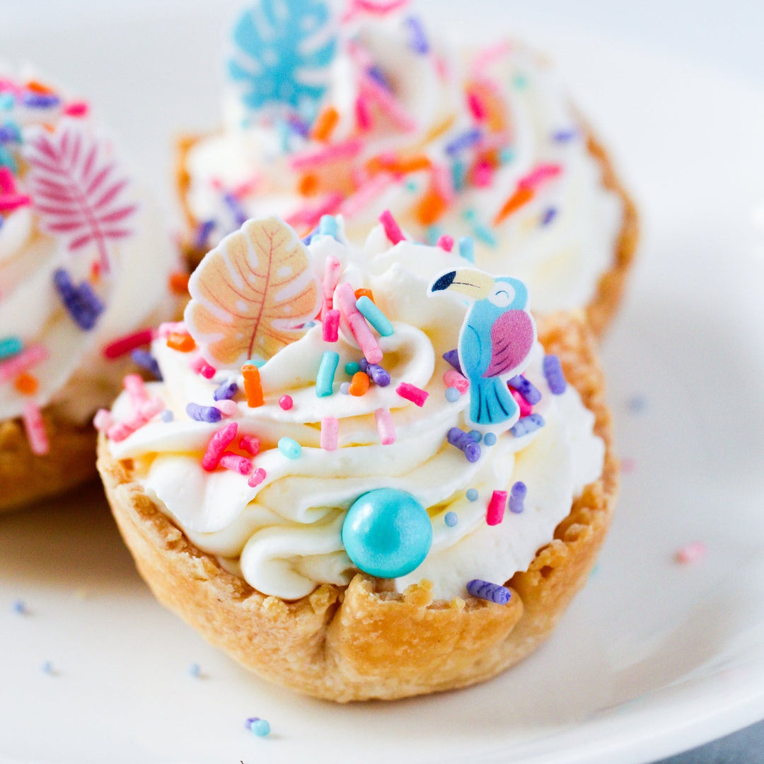 Small tartlette dessert topped with whipped cream and our limited edition Birds In Paradise Sprinkle Mix