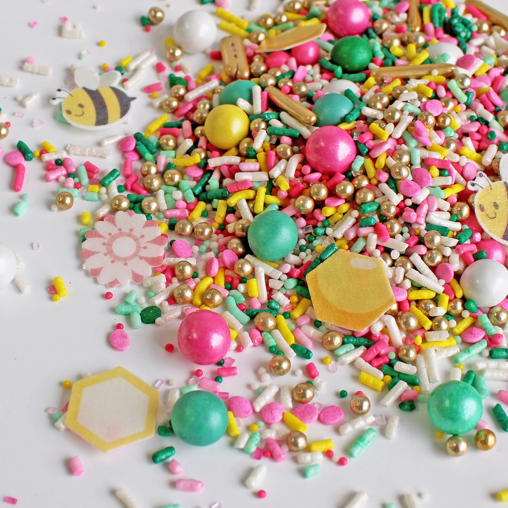 "Bumble Bee Sprinkle Mix with pink, yellow, and mint sprinkles, wafer paper bees and blossoms for spring-themed cake decoration"
