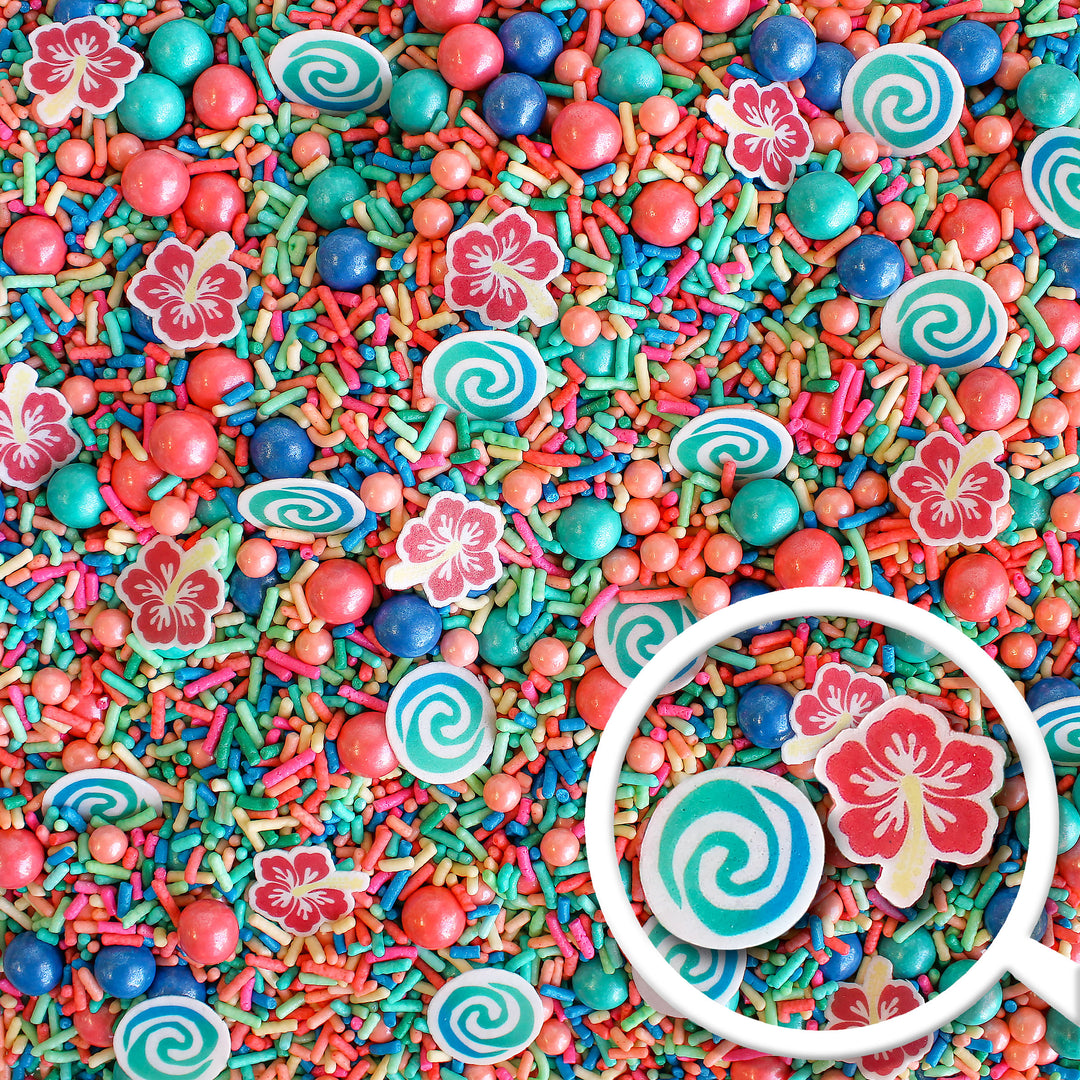 Voyager Sprinkle Mix - A mix of vibrant blue, pink, and teal sprinkles with wafer swirls and tropical flowers.