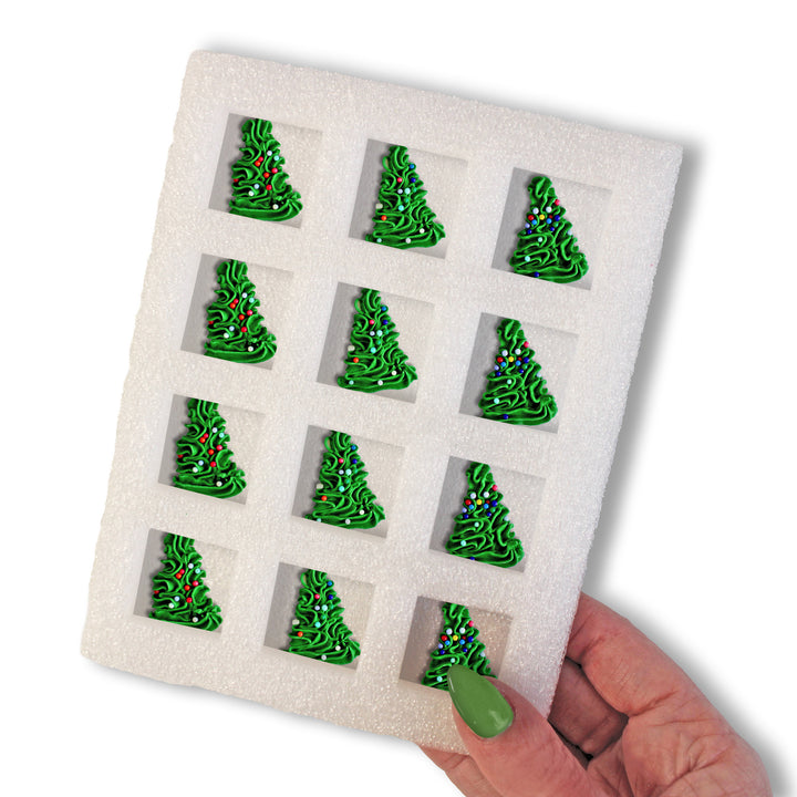 A dozen hand-piped Christmas trees with twinkling lights, perfect for adding festive charm to cakes and cupcakes.