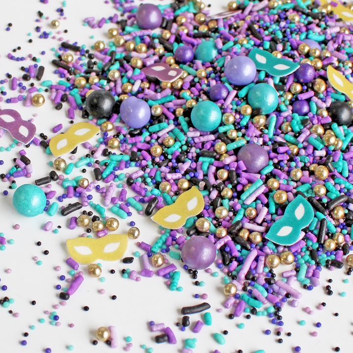 "Masquerade Sprinkle Mix in Mardi Gras colors of teal, black, gold, and purple for festive cake decoration"