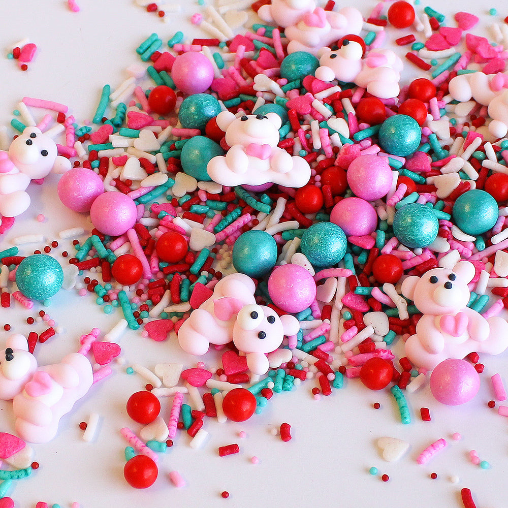 PDA Sprinkle Mix featuring red, light pink, aqua, and white colors with adorable Royal Icing bears and heart confetti for Valentine's Day-inspired baking.