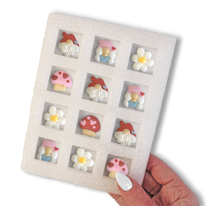 Set of 8 hand-piped royal icing decorations featuring gnomes, mushrooms, and hearts, displayed on a white tray.