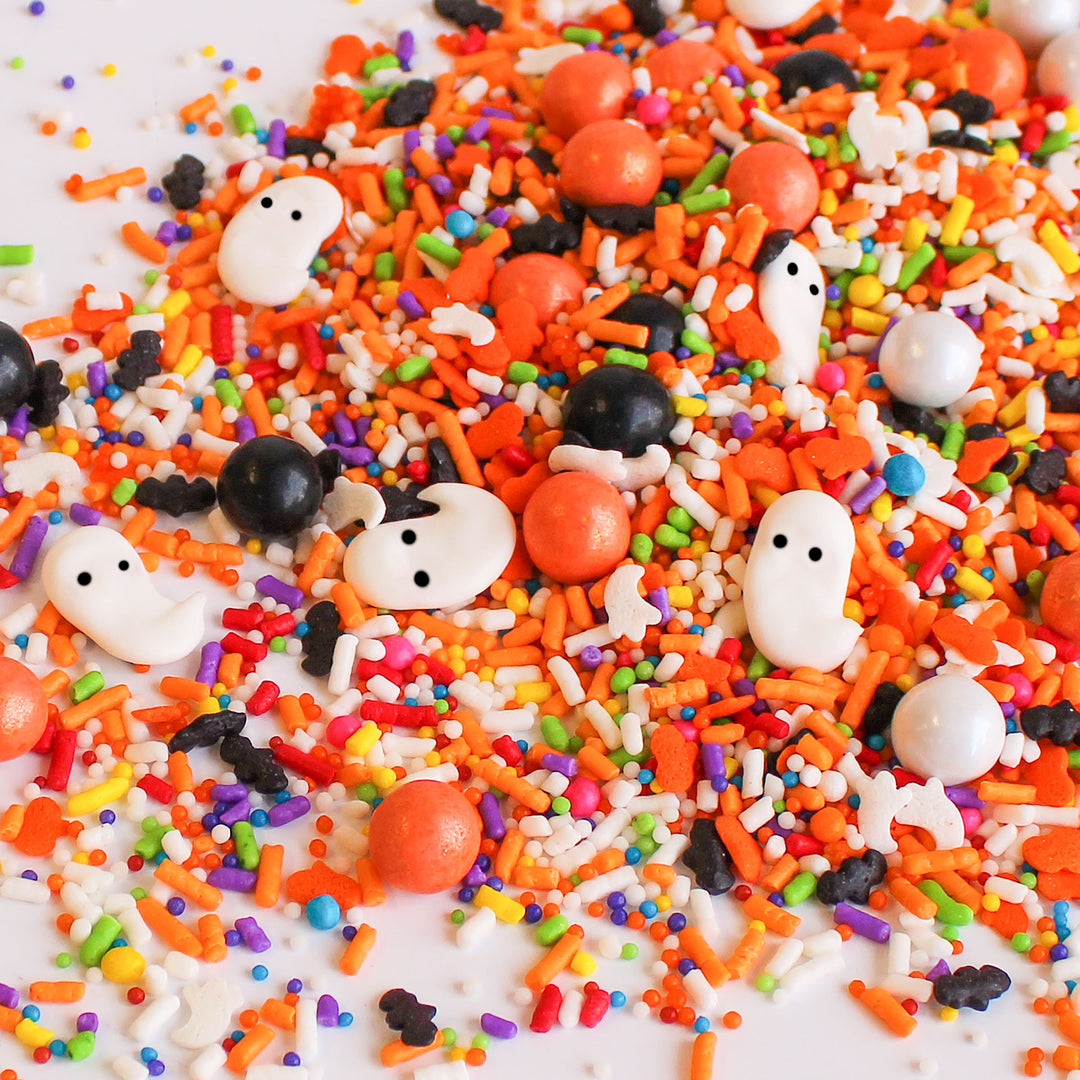 Rainboos Sprinkle Mix - a bewitching blend of black, orange, and pops of rainbow, with hand-piped royal icing rainbows and ghosts, perfect for adding a spooky touch to your Halloween treats.