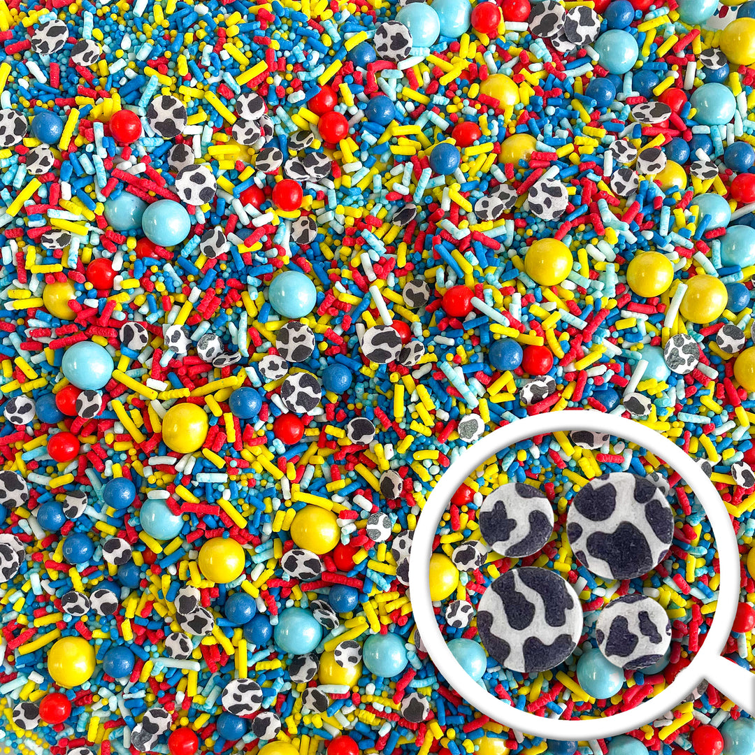 Colorful Story Time Sprinkle Mix with blue, red, and yellow sprinkles, and cow print wafer paper confetti. Perfect for birthday and baby shower themed treats.
