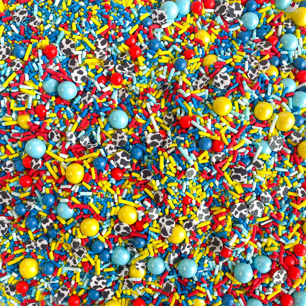 Colorful Story Time Sprinkle Mix with blue, red, and yellow sprinkles, and cow print wafer paper confetti. Perfect for birthday and baby shower themed treats.