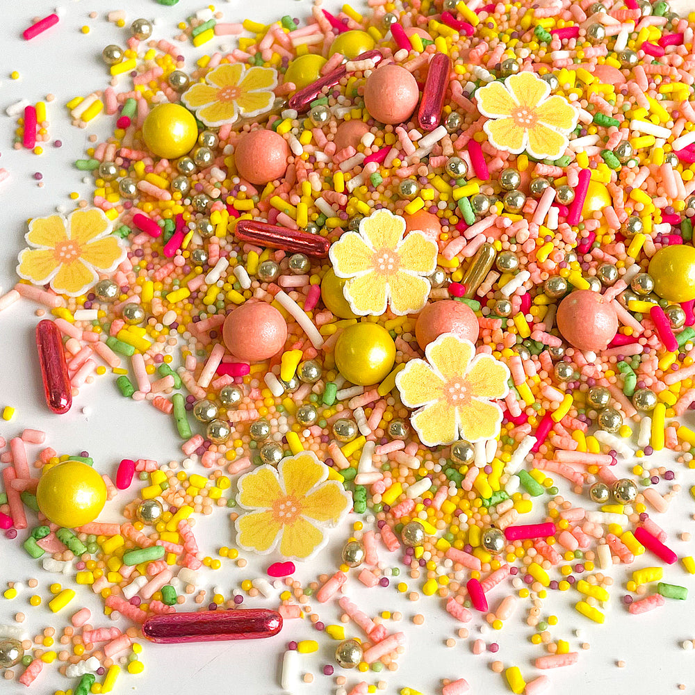Petal Party Sprinkle Mix - A blend of peach and pink sprinkles with delicate yellow blossoms, ideal for cake decorating.