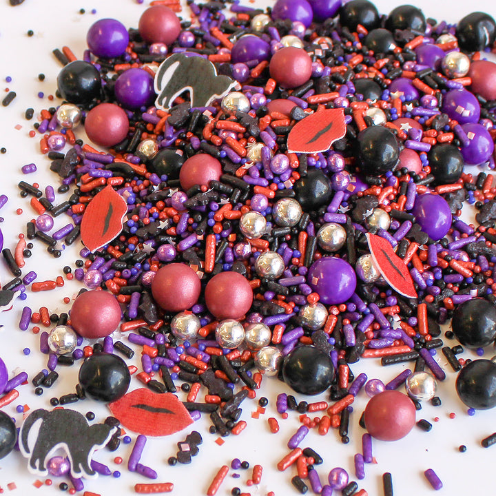 Chilling Sprinkle Mix - Halloween-themed sprinkle mix with purple, black, silver, and burgundy colors, black cat and lip shapes.