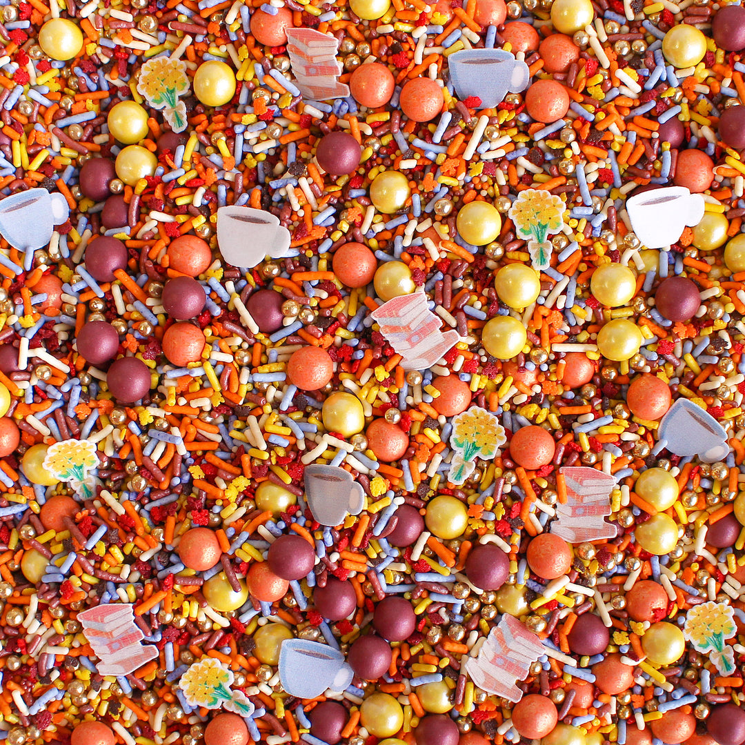 Dragonfly Hollow Sprinkle Mix - A blend of gold, burgundy, orange, and dusty blue sprinkles with wafer flowers, books, and a cup of coffee.