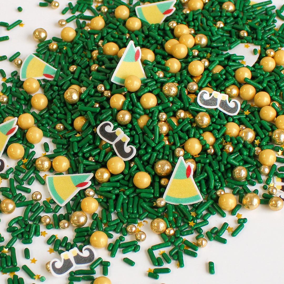Elfin' Around Sprinkle Mix, the perfect Christmas decor for your baked goods. Green sprinkles with gold pearls and cute elf hats and feet.