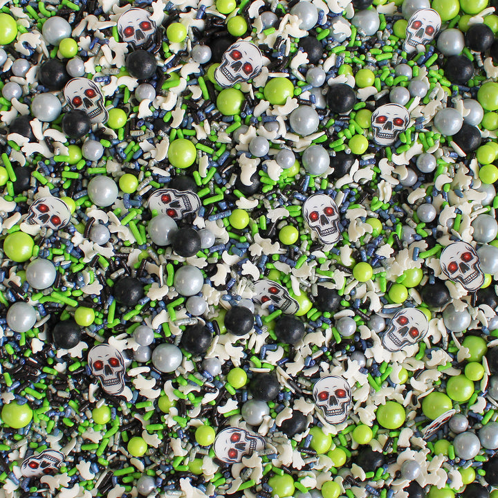 Close-up of Ghost Stories Sprinkle Mix - a captivating blend of lime green, navy, silver, and black sprinkles with wafer skeleton heads and confetti ghosts.