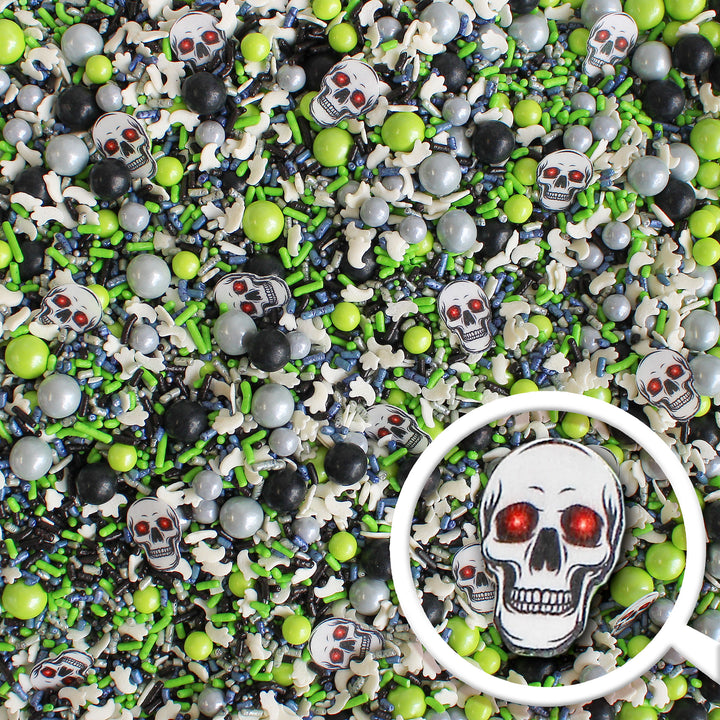 Close-up of Ghost Stories Sprinkle Mix - a captivating blend of lime green, navy, silver, and black sprinkles with wafer skeleton heads and confetti ghosts.