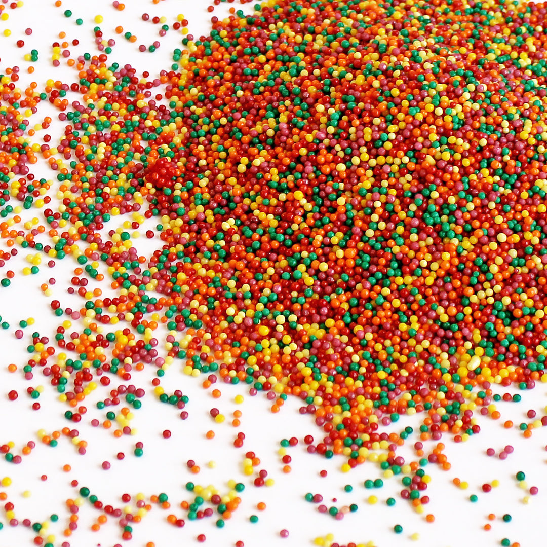 Close-up of Autumn Nonpareils - a mix of red, warm yellow, orange, burgundy, and green sprinkles, perfect for fall treats.