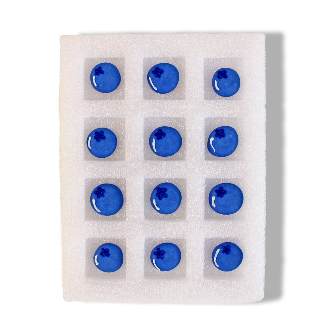 A dozen hand-piped Royal Icing Blueberries with a sweet vanilla flavor, perfect for adding a pop of color and fruity flavor to your baked goods.