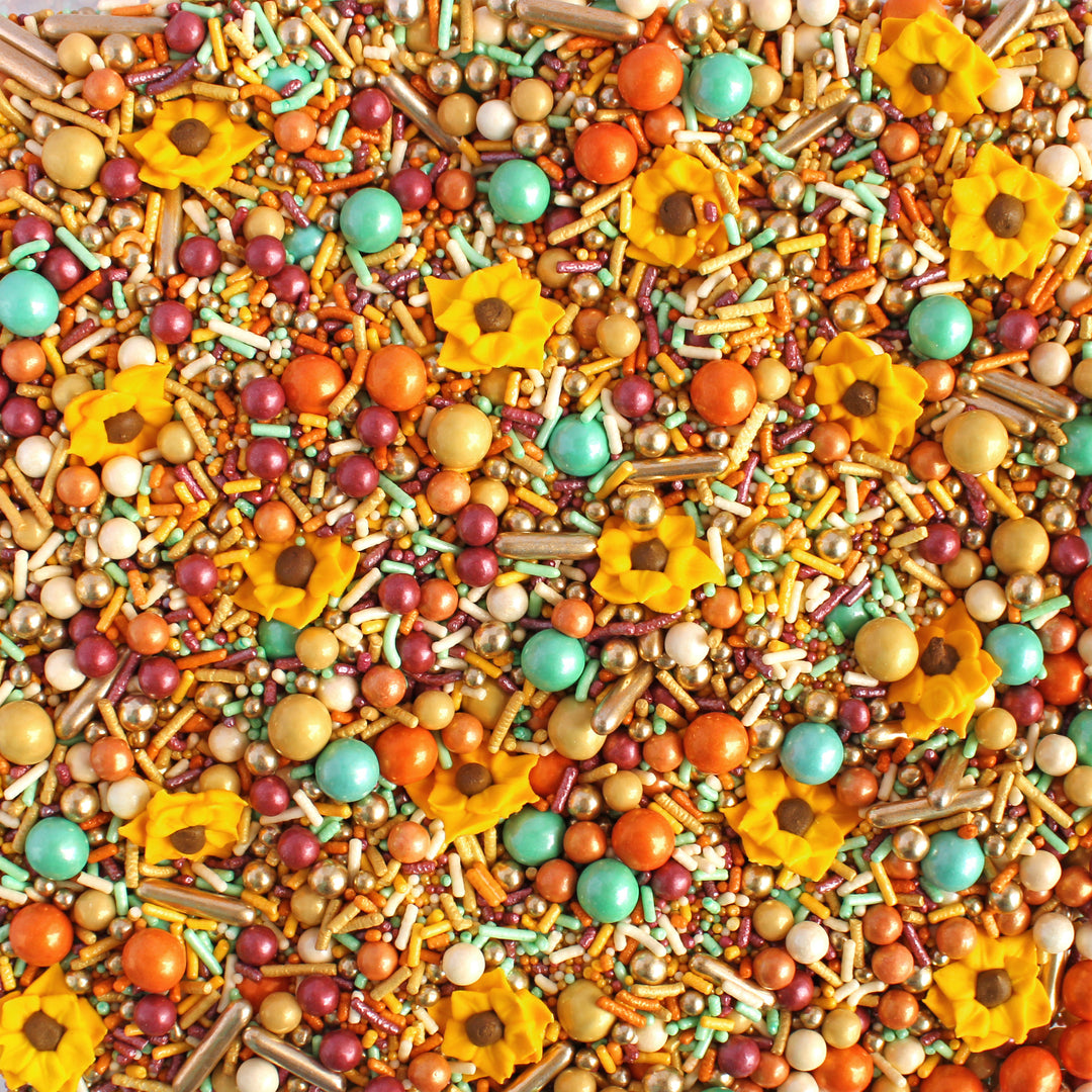 Close-up of Sunflower Sprinkle Mix - a blend of warm burgundy, golden yellow, orange, and a vibrant mint, adorned with hand-piped royal icing sunflower sprinkles.