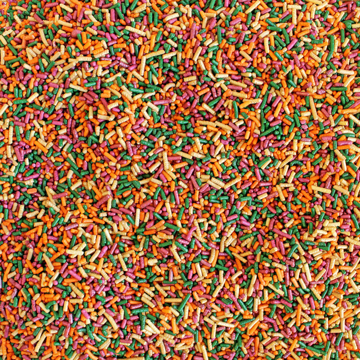 Close-up of Fall Vibes Sprinkle Mix - a blend of burgundy, burnt orange, gold, and green decorettes, ideal for fall-themed baking.