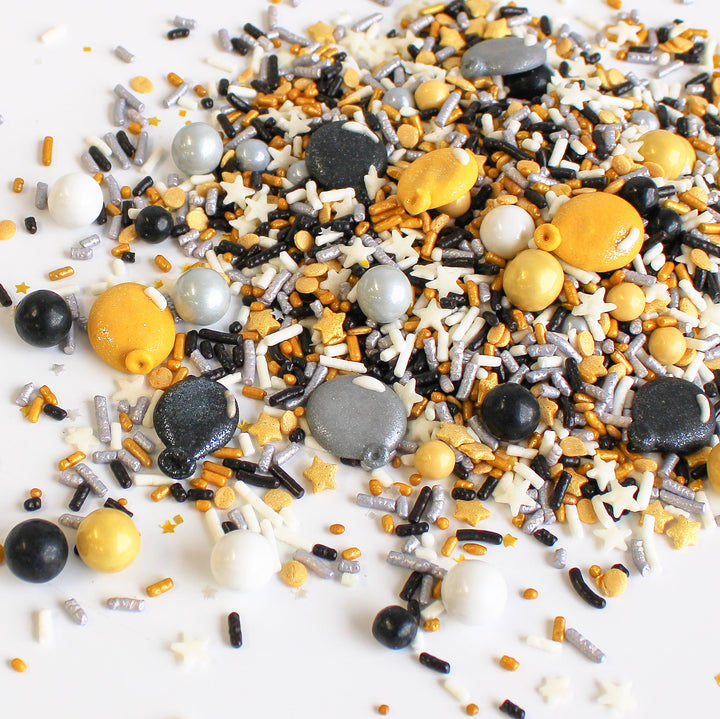 Image of Graduation Sprinkle Mix with black, gold, and silver sprinkles, and royal icing glittery balloons.