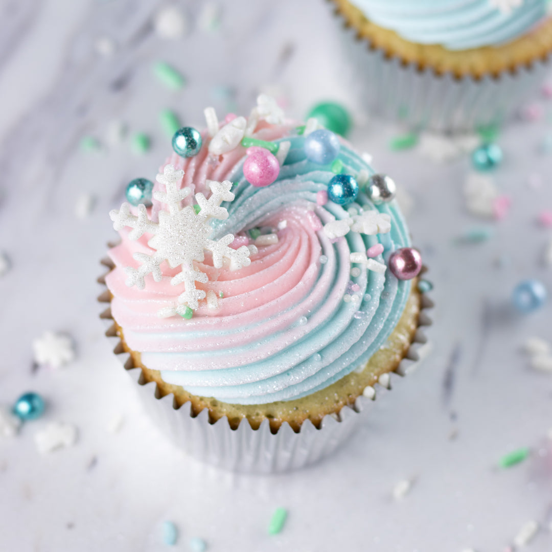 Close-up of a delightful winter dessert adorned with pastel-infused sprinkles, snowflake confetti, metallic dragees, and mini marshmallows, creating a snowy pastel wonderland on sweet treats.